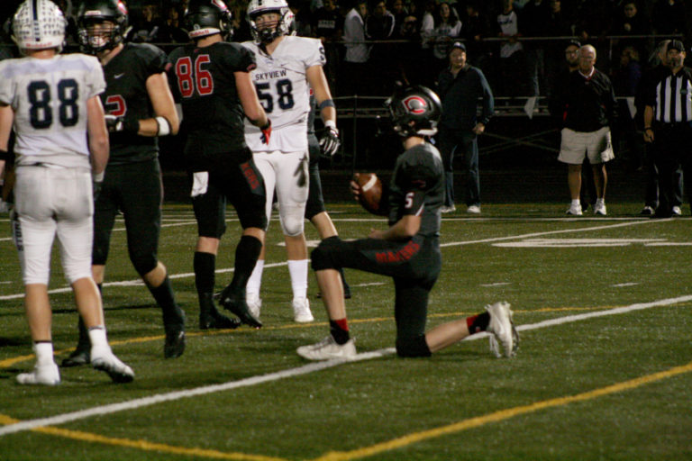 Backup QB Blake Asciutto takes a knee in the victory formation as the clock runs out on Skyview.