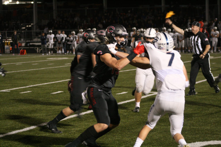 Camas wide receiver Luc Sturbelle (third from left) blocks for his team, while the referee throws a penalty flag.