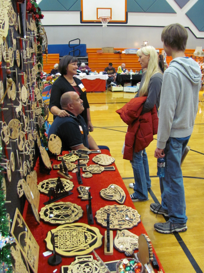 Larry and Cheryl Saari (at left) sell holiday ornaments and other scroll saw wood art at a past Holiday Marketplace bazaar at Washougal High School. This year&#039;s Holiday Marketplace Bazaar will be held from 9 a.m. to 4 p.m., Saturday, Nov. 10, at the high school, 1201 39th St., Washougal.
