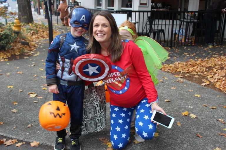 Melinda Kaiser, of Vancouver, wore a "Super Pregnant" shirt to the 2018 Boo Bash candy giveaway in downtown Camas, on Wednesday, Oct. 24. Kaiser, who was four weeks away from her due date, poses with her children, Jackson, 5 (left), and Harper, 3 (hiding behind mom). 
