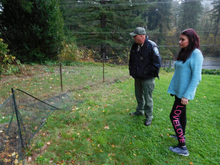 Washington Department of Fish and Wildlife Officer Thomas Moats responds to a call from Nataliya Milushkina, Monday, Nov. 5, outside her home near the Washougal River.