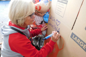 Laura McGuire, of Camas, writes a heartfelt message on a box destined for the wildfire-affected areas of Northern California. McGuire organized a two-day donation effort that inspired Camas and Washougal residents to contribute clothing, camping equipment and personal care items for Californians who had to evacuate their homes.