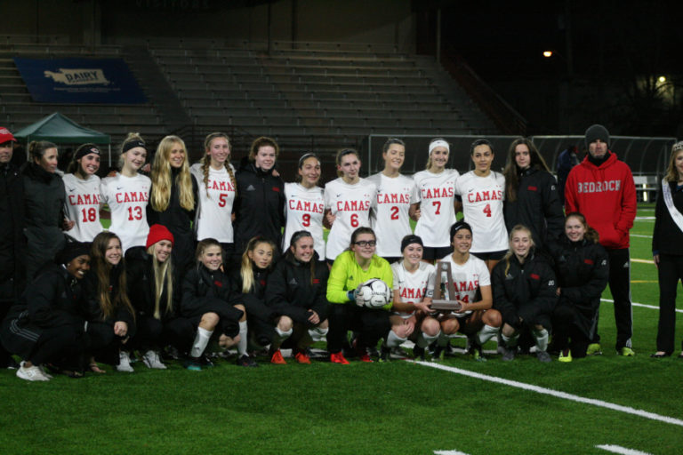 Tears are forced into smiles as the Papermakers pose for pictures with the runner-up trophy minutes after losing 2-1 to Skyline in the state title game, Nov.