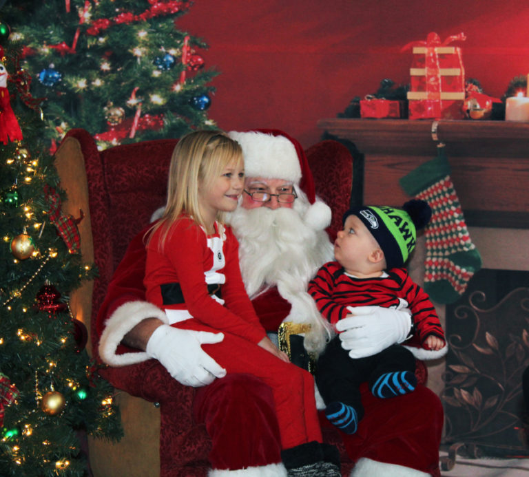 Above, Santa greets children at the 2017 Hometown Holidays celebration in downtown Camas. At right, Camas city staff put this year&#039;s Hometown Holidays tree up in downtown Camas this week. Camas Mayor Shannon Turk will light the tree during the annual holiday celebration on Friday, Dec. 7.