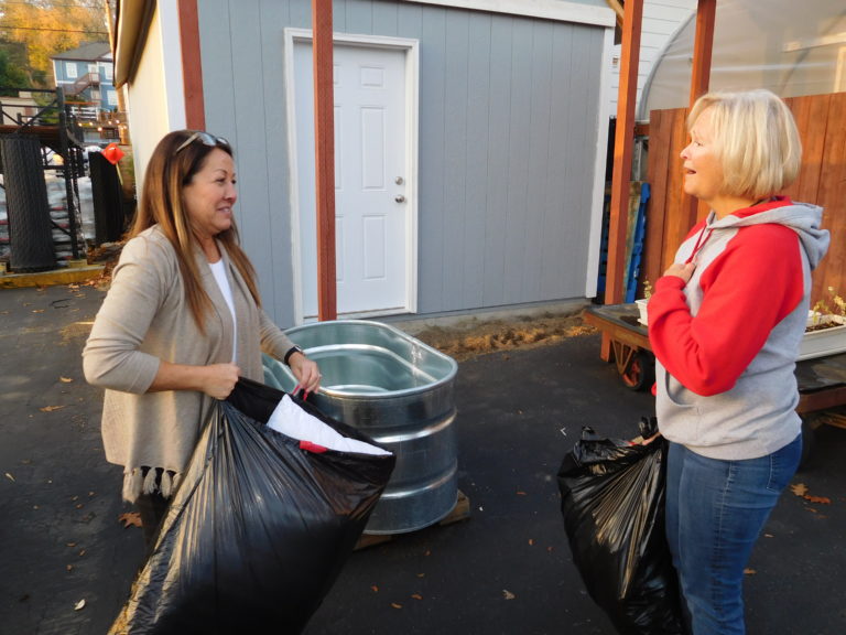 (Dawn Feldhaus/Post-Record) Lori Fernandez, of Camas (left), is among the local residents donating clothing and other items, at Lutz Hardware, in downtown Camas, for wildfire-devastated residents of Paradise, Calif.