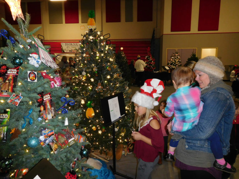 A family admires Christmas trees, decorated in themes inspired by Star Wars and holiday traditions from around the world, at the 2017 Washougal Festival of Trees. This year&#039;s festival, which benefits Washougal schools, will be held Dec.