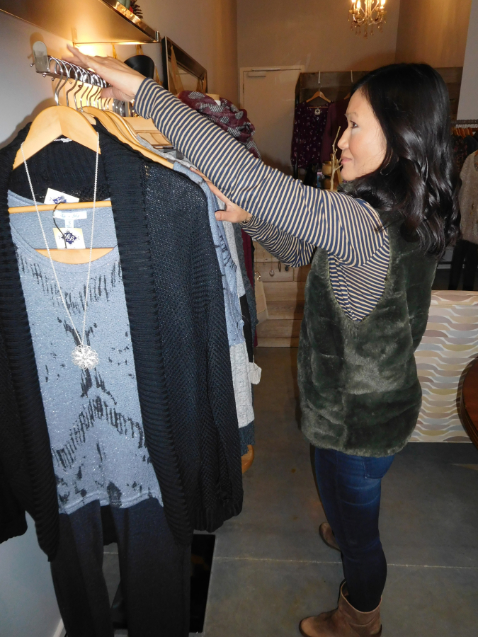 Lulu Suchinda, owner of Lulu&#039;s Boutique, arranges her inventory of women&#039;s clothing and accessories Dec. 1.