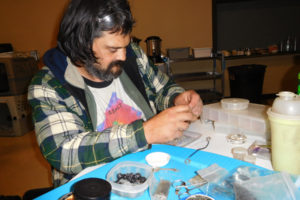 Jeremy Bye, 41, makes jewelry while staying at a severe weather shelter, Dec. 5, in the Washougal Community Center. The City of Washougal, in partnership with ReFuel Washougal, will open the shelter again when the temperatures drop below 30 degrees or there is snow or ice in the forecast and there are enough volunteers to staff the shelter. 