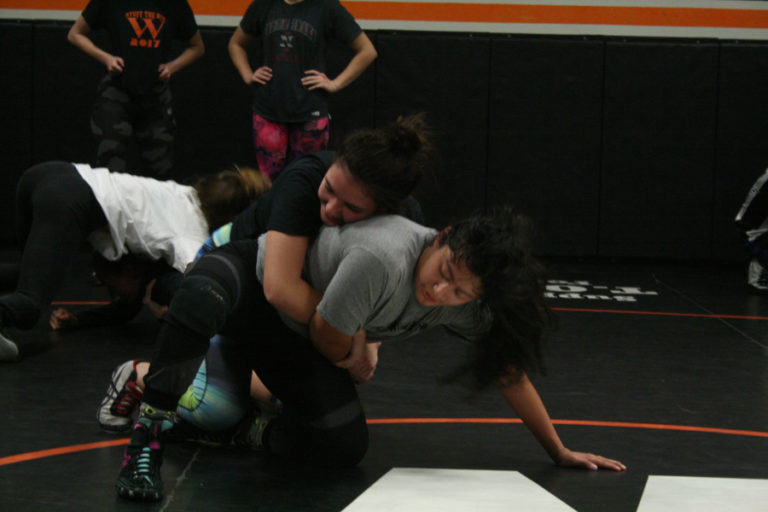 Panther co-captain senior Jenna Beaver (blue and green pants) practices moves with sophomore Melina Aguilar.