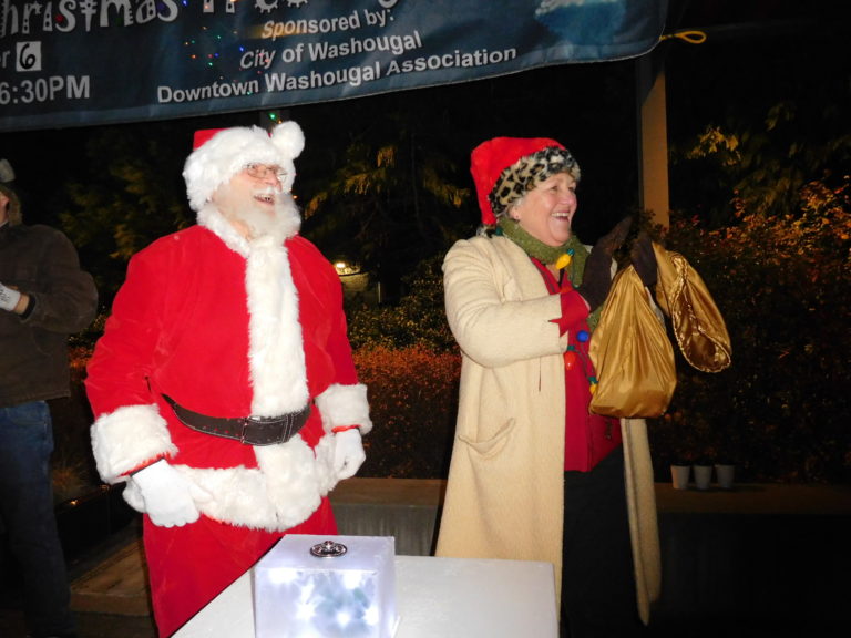 (Dawn Feldhaus/Post-Record)  Santa Claus and Washougal Mayor Molly Coston celebrate the lighting of the Christmas tree in Reflection Plaza, Dec. 6.

