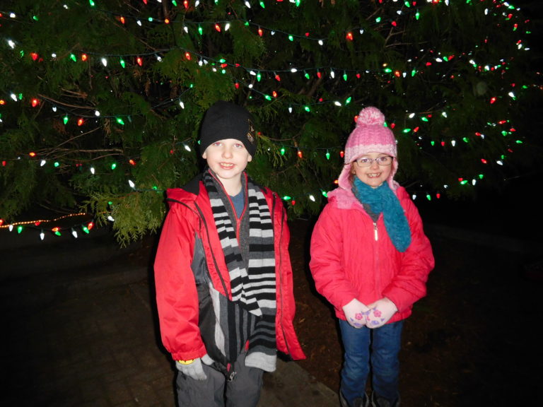 (Dawn Feldhaus/Post-Record) Major Hay and his sister, Keira Hay, take part in a photo opportunity, Dec. 6, in front of the Christmas tree, in Reflection Plaza, in downtown Washougal.

