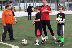 Rocky Fresh (second from right) shows three TOPSoccer youth the ins and outs of controlling a soccer ball at the Salmon Creek Indoor Soccer Center.