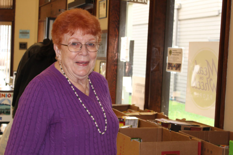 Ann Prouty and her husband, Kay Prouty (not pictured), regularly transport food from the food bank to the Washougal Senior Center for seniors to pick up fresh fruit and vegetables, frozen foods and nonperishable canned and boxed goods each week. Here, Prouty is pictured near the senior center&#039;s &quot;food bank line&quot; on Monday, Jan.