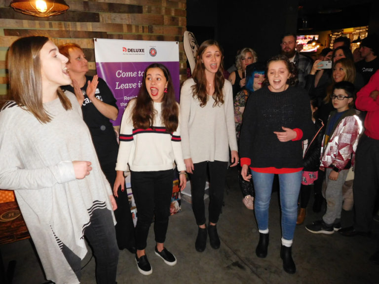 Camas High School students (left to right) Ally Kane, Sami Holm, Julia Watson and Hannah Upkes sing "The Star Spangled Banner" and "Please Mr. Postman" during a Jan.