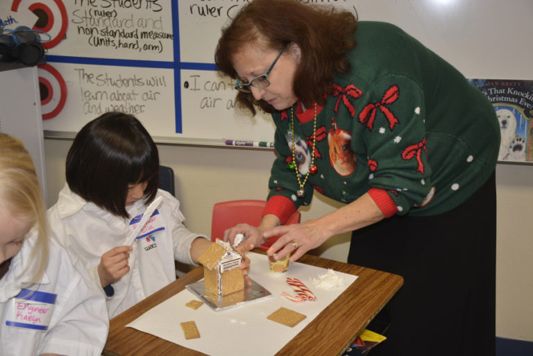 At left, teacher  Marvina Bugajksi helps Ella Shimata work on a gingerbread house on Dec.