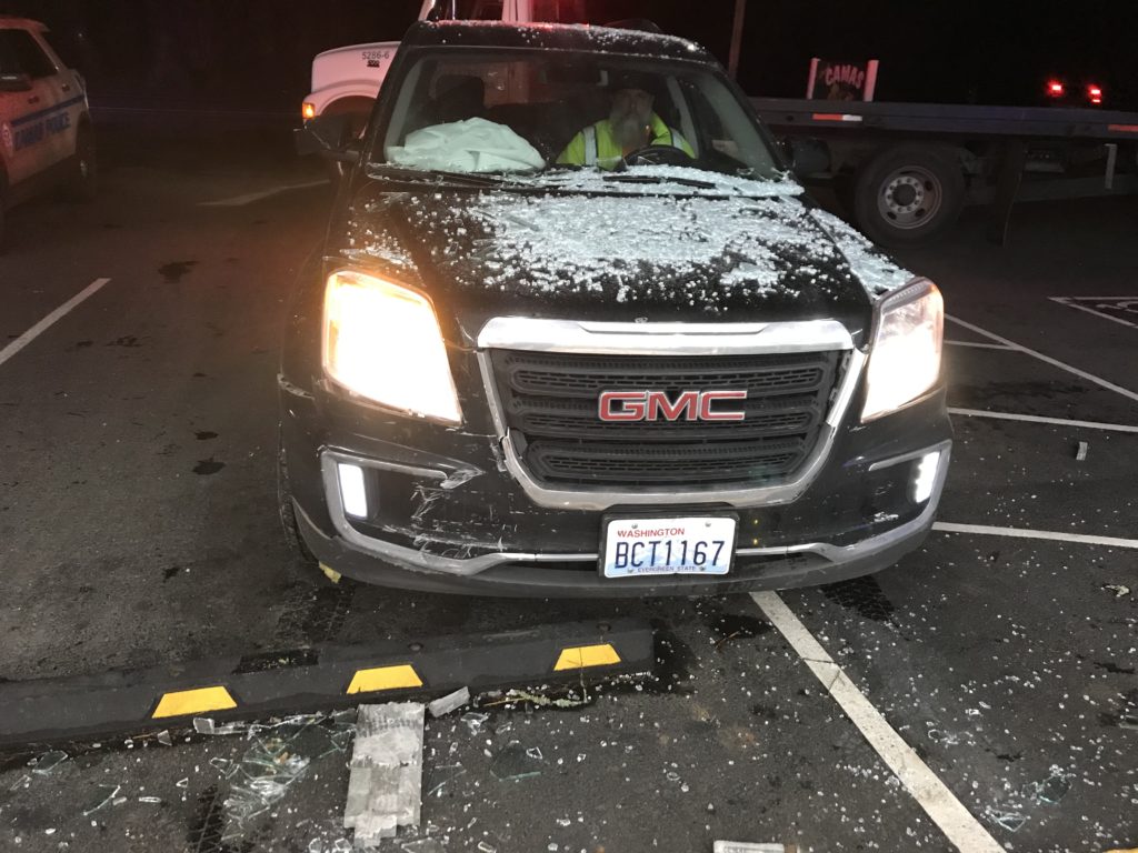A tow truck driver prepared to tow a GMC from the site of a crash that sent the car through the front windows of Camas Produce Thursday evening, but caused no injuries to the driver or employees/customers at the Camas grocery market.