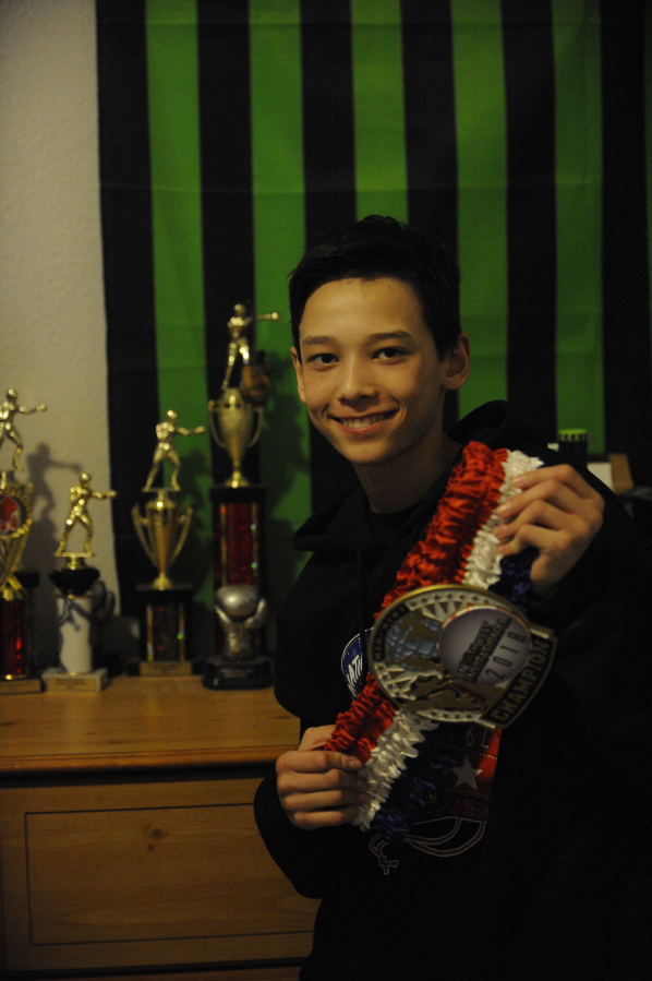 Ben Schluter, a 14-year-old Camas boxer, shows off his fast growing trophy and belt collection at his Prune Hill home.