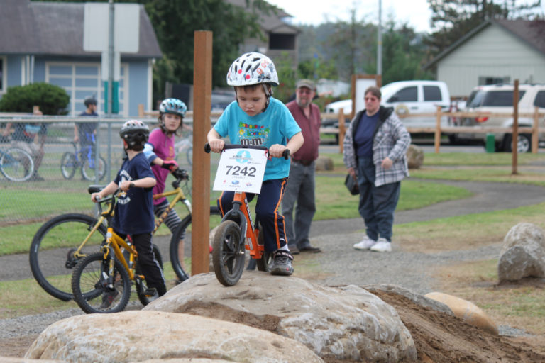 Children participate in opening day of a bicycle skills course at Hamllik Park, in Washougal, in October 2016. The course, which makes its way around the perimeter of the park, includes natural rock and cedar log features, ladder bridges and ramps.