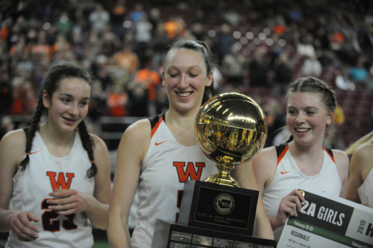 Beyonce Bea (center) and her teammates hold the 2A state basketball trophy on March 2, at the Yakima Valley SunDome.