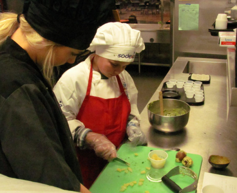 Columbia River Gorge Elementary School fourth-grader Skylar Stotts (right) prepares pineapple guacamole with the help of his sister McKinley on March 6 during the Sodexo Future Chefs Challenge at Washougal High School.