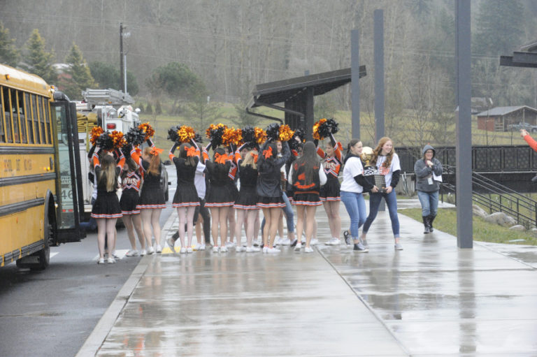 The Washougal cheerleaders help the Washougal girls basketball team exit the bus to visit students at Columbia River Gorge Elementary School.
