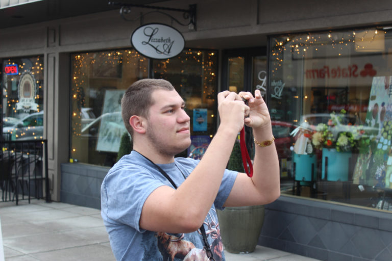 Nolan Schaffer, 17, an 11th-grader at the Washington State School for the Blind, takes a photo in downtown Camas on March 11.