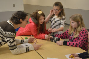 Washougal Community Library's Rachael Ries works with Columbia River Gorge Elementary School students Lauren Byrne, Aubrey Timmons and Bailey Wright during a coding club session last month. (Contributed photo courtesy of Rene Carroll)
