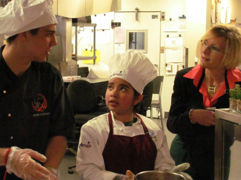 Washougal School District superintendent Mary Templeton (right) chats with Washougal High School senior Michael Gonser (left) and Jocelyn Guajardo, a fifth-grader at Gause Elementary School, during the Sodexo Future Chefs Challenge at Washougal High School on March 6.
