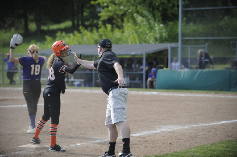 Washougal softball coach John Carver high fives senior Layci Livengood after she knocked in several runs with a triple in a 15-4 loss to Columbia River on April 29.