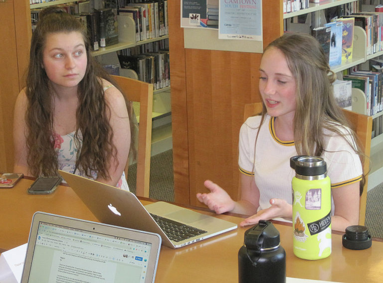 Camas High School students Maggie Wood (left) and Daria Oviatt talk about the upcoming TEDxYouth@Camas event during a speaker workshop May 11 at Camas Public Library.