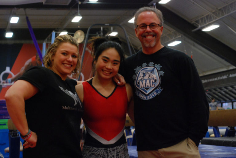 Kaylee Sugimoto (center) stands with her two coaches, Cassandra Jusino (left), who helps her with floor and beam, and Rob Petit (right), an expert in bars and vault.