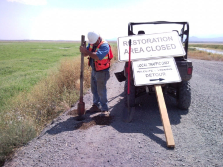 Jim Erion, of LKE Corporation, installs a restoration sign at a refuge near Doris, Calif.
