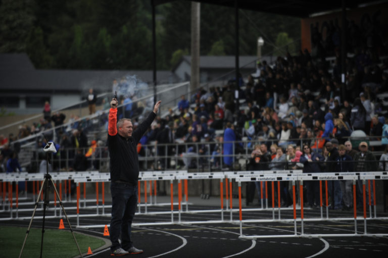 Washougal associate principal Gary McGarvie fires the starting gun at the 2A district championships.