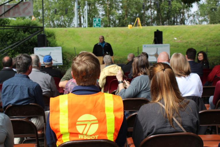 A crowd, including crews from the Washington State Department of Transportation (WSDOT), listens to speakers in the parking lot of the Pendleton Woolen Mills store in Washougal on May 23, at a groundbreaking for two traffic roundabouts being built on state route 14 in Washougal.