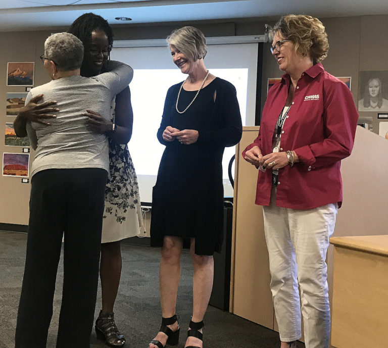 Camas School District (CSD) Assistant Superintendent Charlene Williams (second from left) hugs Educational Service District 112 early learning trainer Tracy Collins during a May 13 Camas school board meeting, while CSD Assistant Superintendent Lisa Greseth (second from right) and the school district's director of talent development, Marilyn Boerke (right), look on.