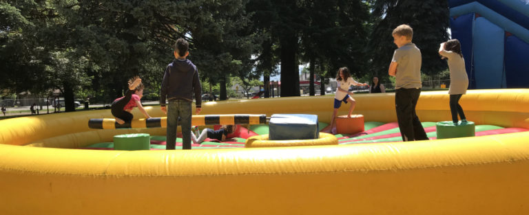Children jump on an inflatable toy during the CamTown Youth Festival, held June 1, in Crown Park. The event, put on by the city of Camas, featured a variety of games, crafts, activities, entertainment, food, an art show, a petting zoo and a children&#039;s flea market.