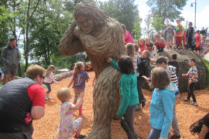 A group of children surround and climb a sasquatch sculpture June 7 at a grand opening event for the natural play area at Washougal Riverfront Park and Trail. (Doug Flanagan/Post-Record)