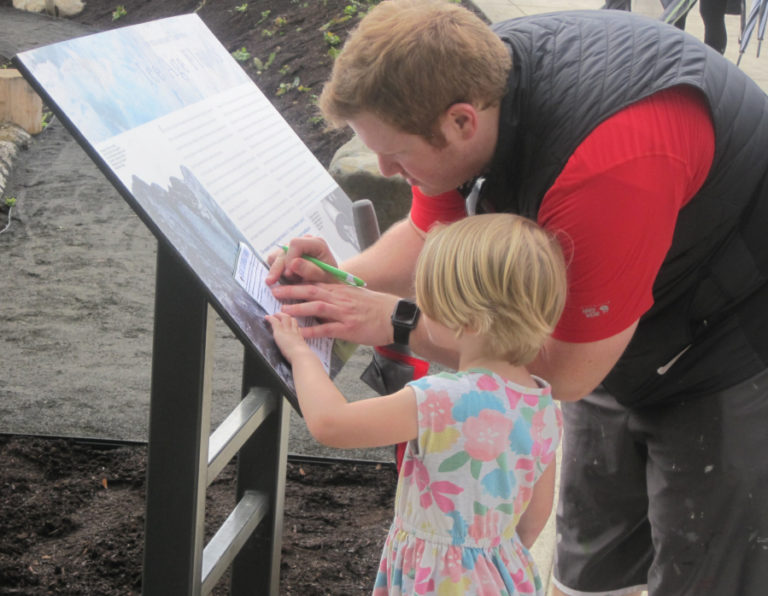 Camas resident Ben Miles helps his daughter, Lillian, 2, with a scavenger hunt on Friday, June 7, at a grand opening event for the natural play area at Washougal Riverfront Park and Trail.