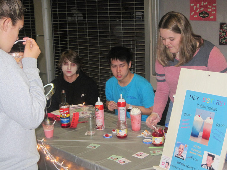 Megan Bauer (right) serves an Italian soda while teammates Drew Hancock (left) and Brian Lee look on during the &quot;Thirsty Thursday&quot; event June 6 at Camas High School.