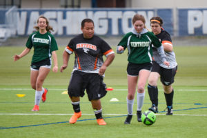 Andrew Valenzuala (second from left) chases after the ball while his teammate Kaitlynn McKee assists from behind during the unified state soccer tournament in May. (Contributed photos courtesy of Washougal High School)