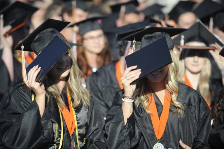 Washougal High class of 2019 graduates use their diplomas to shield their faces from the bright sun during their graduation ceremony on Saturday, June 8, at Fishback Stadium in Washougal.