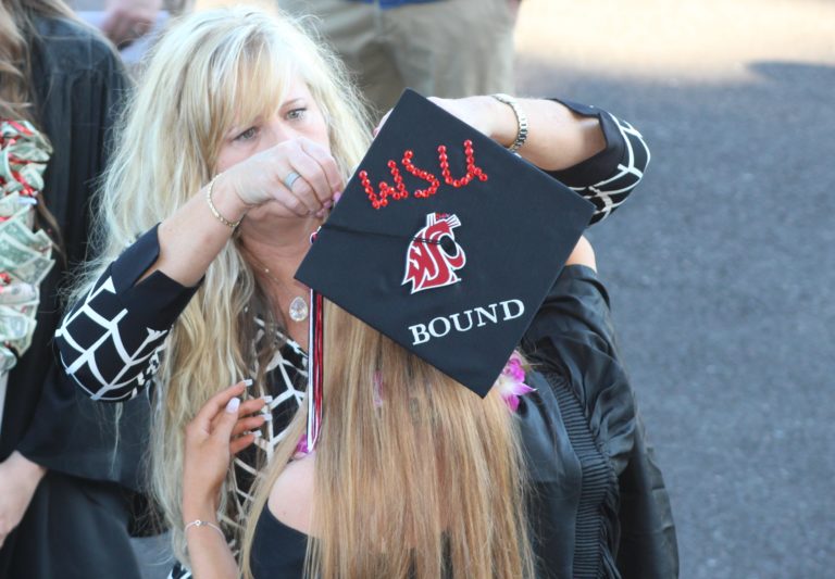 (Photo by Kelly Moyer/Post-Record)
A woman helps a Camas High School class of 2019 graduate pin her “WSU Bound” cap to her hair before the June 14 graduation ceremony at Doc Harris Stadium in Camas. 