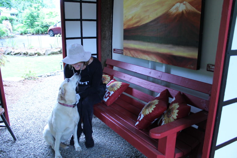 Liz Pike gives her dog, Maxie, some love inside the Japanese style tea house Pike built on her Shangri-La Farm north of Camas.