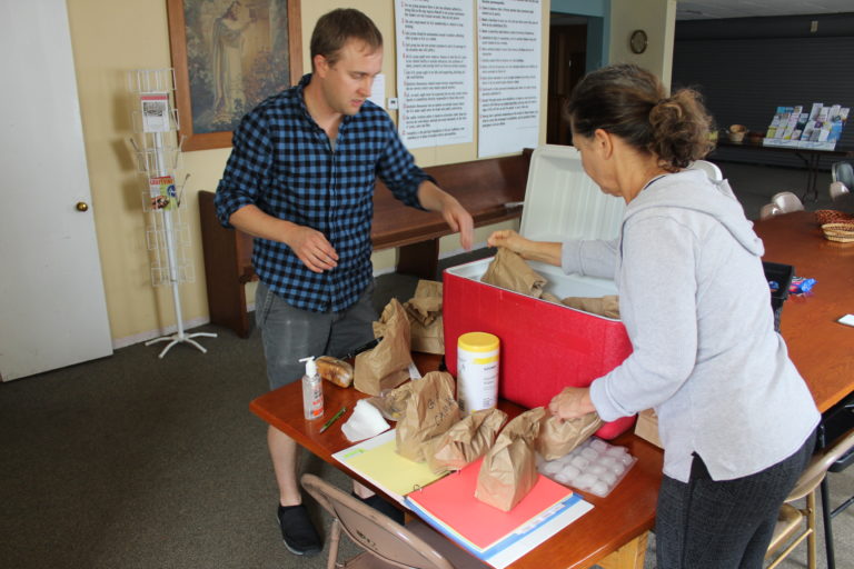 Camas Friends Church Pastor Matt Boswell (left) and volunteer Judy Kaye count and sort lunches for the church’s free summer lunch program on Monday, June 24.