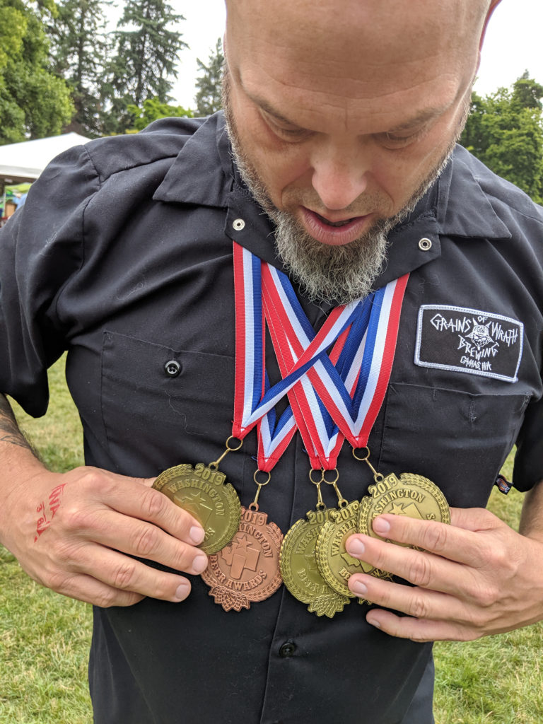 Grains of Wrath Brewing co-founder Mike Hunsaker displays the five medals his brewery won at the Washington Beer Awards earlier this month.