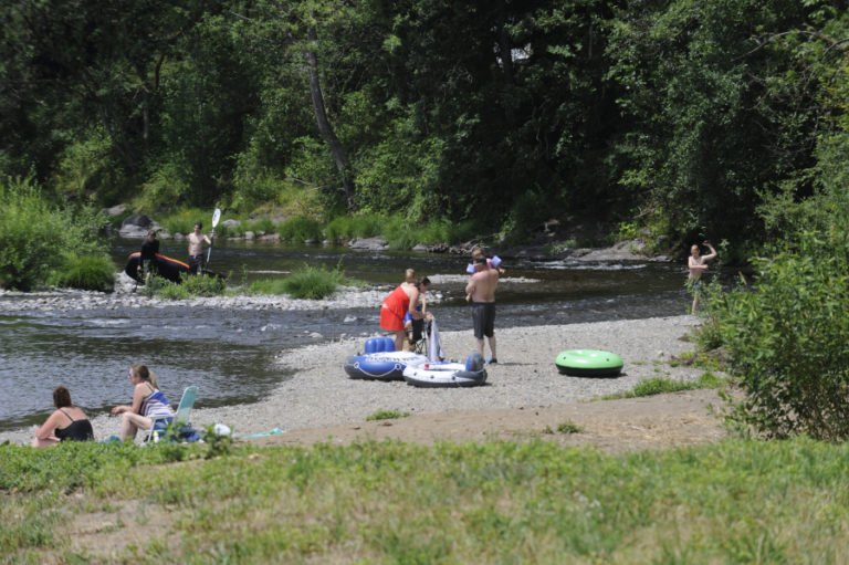 Visitors enjoy the cool waters and peaceful setting of the Sandy Swimming Hole park in Washougal on July 12.