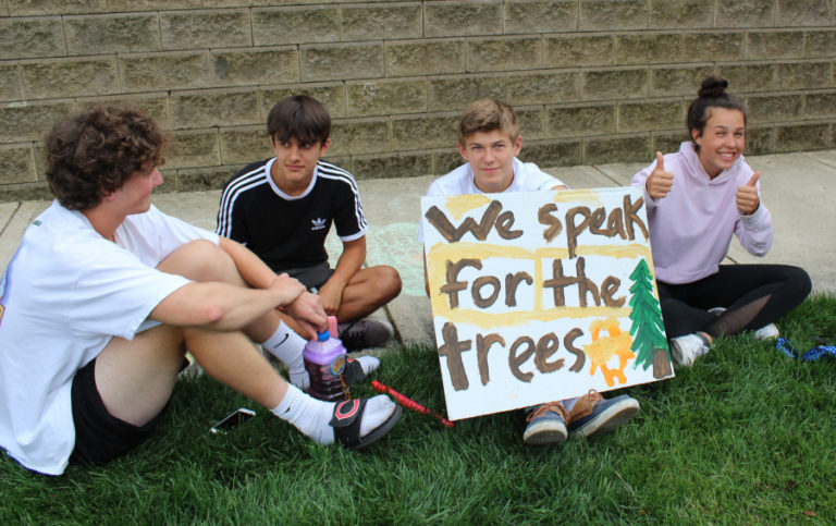 At left, youth from the Camas Tree Protectors group hold a &quot;We speak for the trees&quot; sign at a July 17 event.