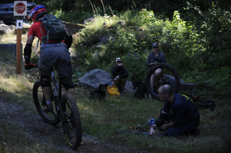 Bike racers rest and make repairs at the bottom of a new race trail called Sixth Sense during the Yacolt Burn Enduro.