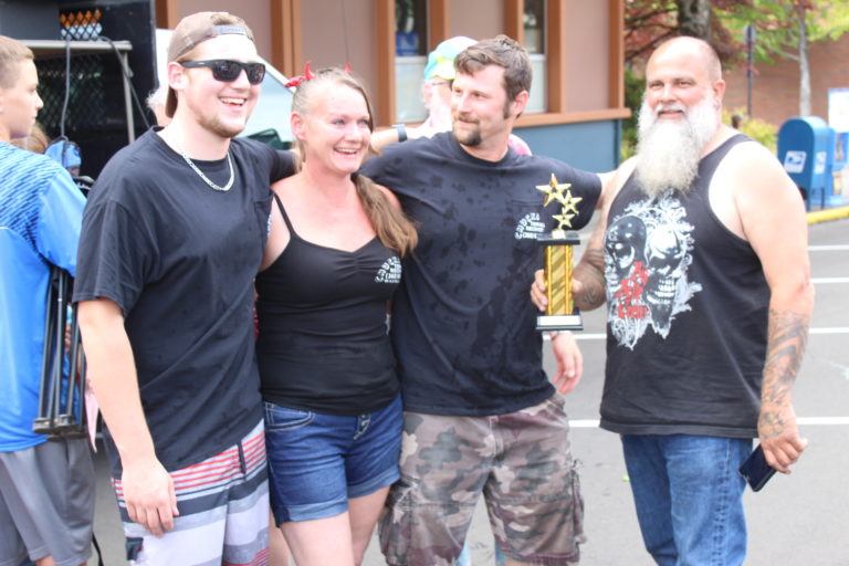 Members of the Chuck's Towing team, also known as the Bathtub Bandits, receive the first-place trophy after winning the Bathtub Races competition on Saturday, July 27.