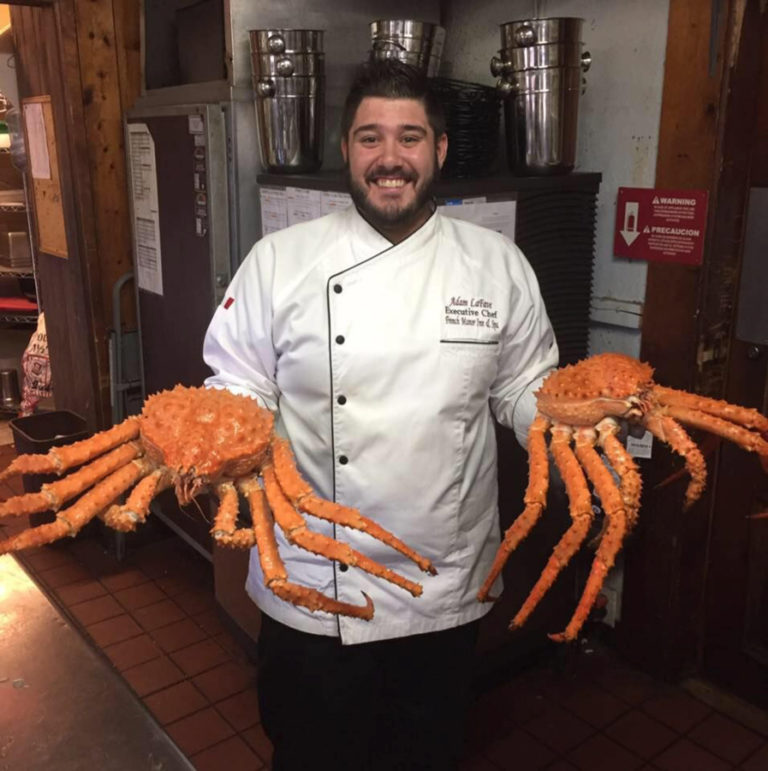 Chef Adam LaFave holds crabs provided by Foods In Season.
